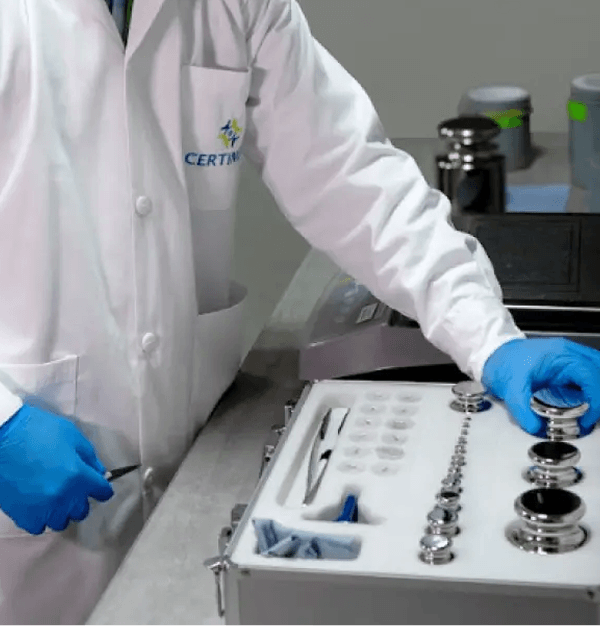 Técnico calibrando pesas patrón en laboratorio