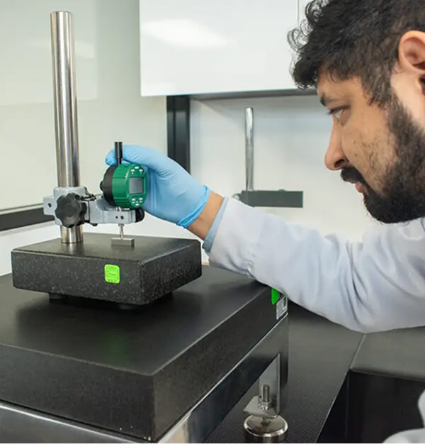 Técnico calibrando pesas patrón en laboratorio